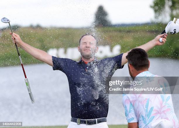 Branden Grace of Stinger GC is sprayed with champagne by Team Captain Louis Oosthuizen of Stinger GC after winning on the 18th green during day three...