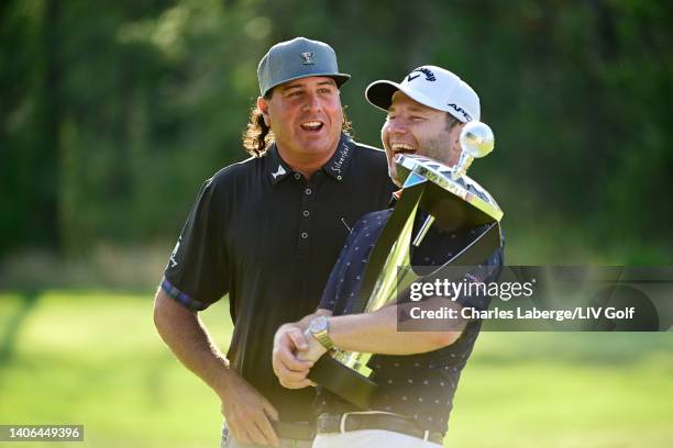 Branden Grace of Stinger GC poses with the trophy after winning first place individual award as he laughs with Pat Perez of 4 Aces GC during day...