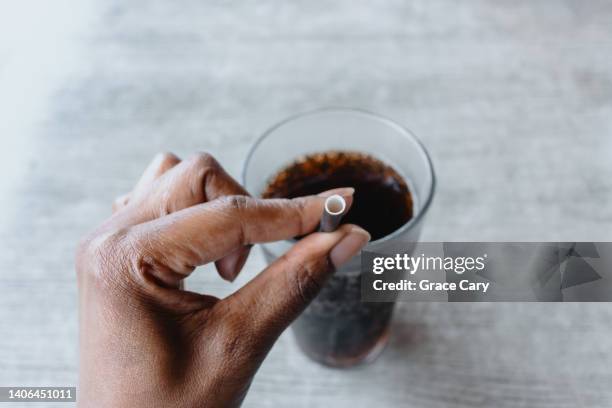 woman drinks beverage with paper straw at restaurant - dr pepper stockfoto's en -beelden