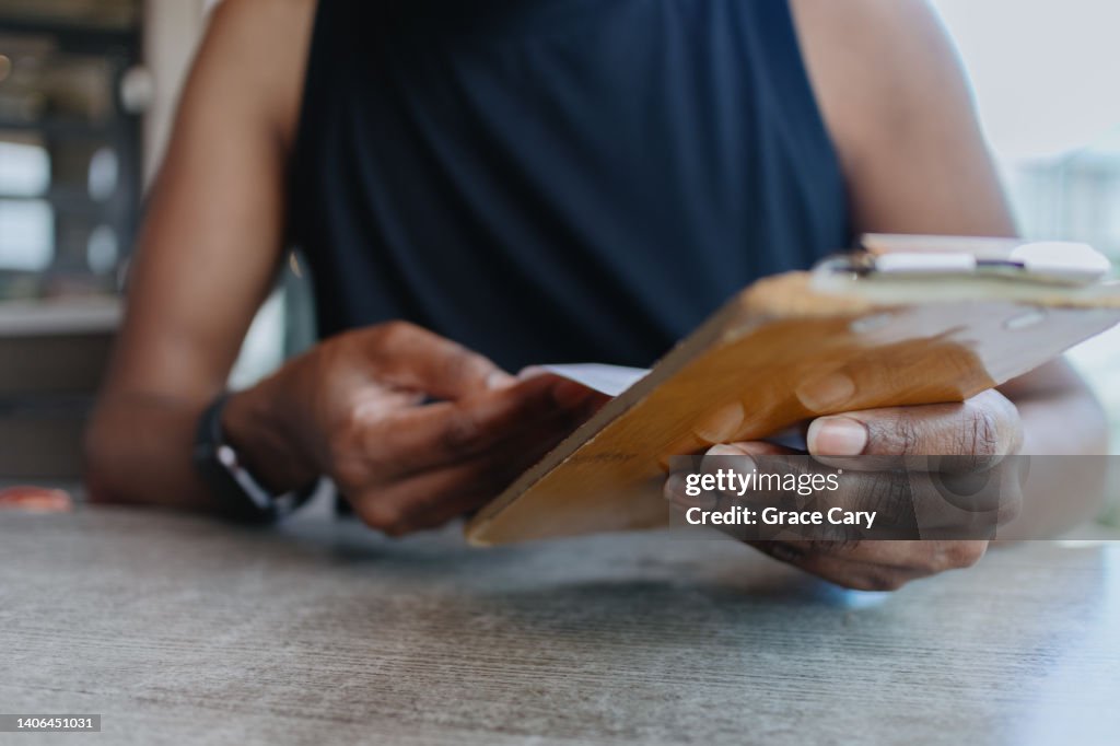 Woman Reviews Bill at Restaurant