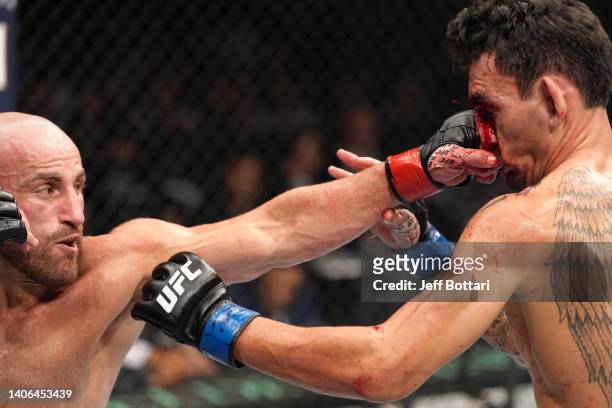 Alexander Volkanovski of Australia punches Max Holloway in the UFC featherweight championship fight during the UFC 276 event at T-Mobile Arena on...