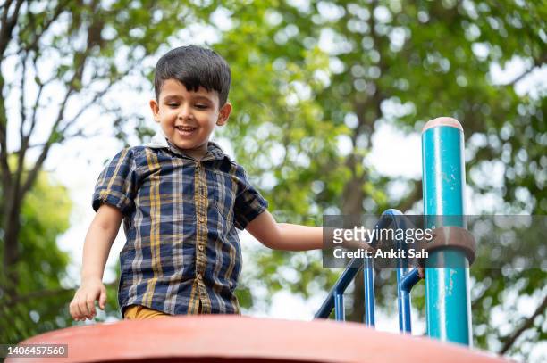 boy having fun on slide at playground - portrait looking down stock pictures, royalty-free photos & images