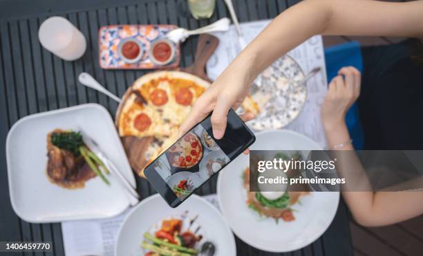 luxury food lifestyle asian generation z women lifestyle enjoy fine dinning at chaopraya riverside using mobilephone photographing live social media with sunset scenics view restaurant in bangkok thailand - asian generation z stock pictures, royalty-free photos & images