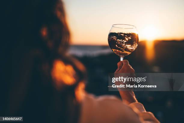 relaxed woman drinking wine at the terrace at sunset. - the 4th annual all star state of mind celebration stockfoto's en -beelden