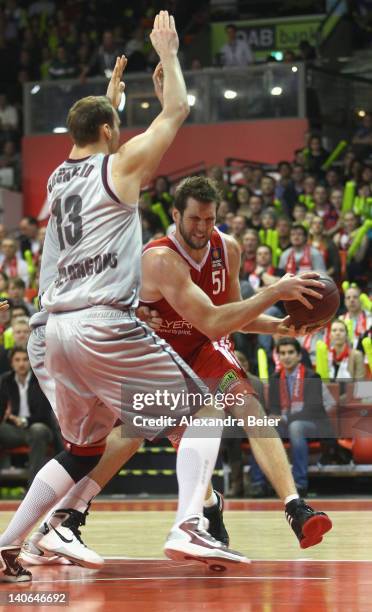 Jared Homan of Bayern Muenchen fights against Guido Gruenheid of Artland Dragons during the basketball Bundesliga match between FC Bayern Muenchen...