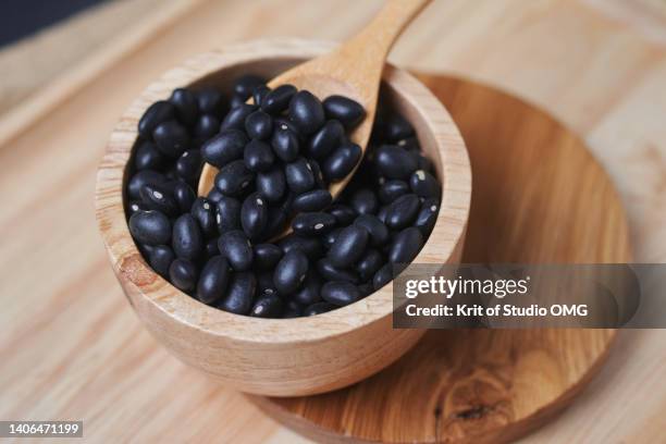 the black beans and wooden spoon in a wooden cup - black beans stock pictures, royalty-free photos & images