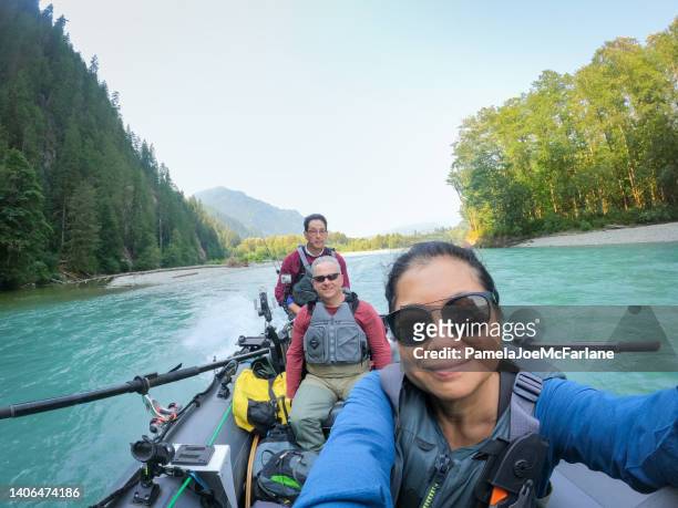 60+ senior multiracial friends riding boat while freshwater river fishing - three people selfie stock pictures, royalty-free photos & images