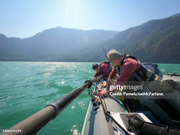 60+ senior multiracial friends making adjustments on recreational fishing boat - bc commercial fishing boats stock pictures, royalty-free photos & images