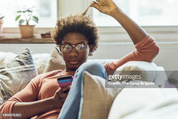 young woman using smart phone at home - 18 19 anos - fotografias e filmes do acervo