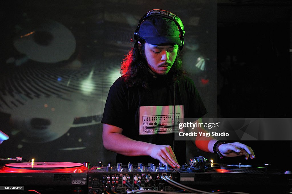 Young male DJ at record decks in nightclub,Japan
