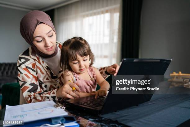 middle eastern mother working from home with kid - turkey middle east stockfoto's en -beelden