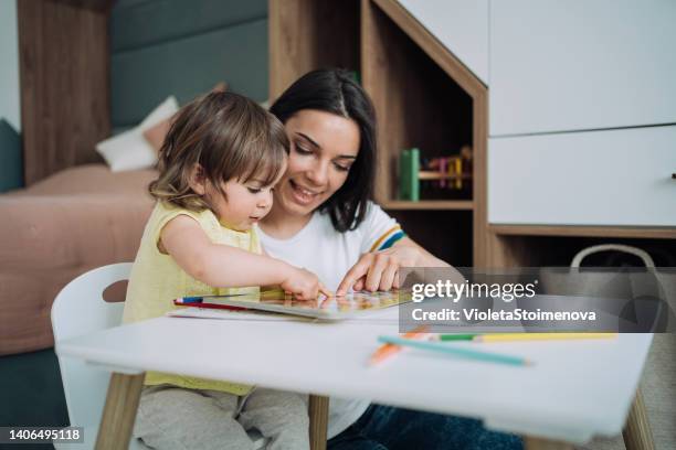 mutter und ihr kleines mädchen ziehen zu hause zusammen. - day care stock-fotos und bilder