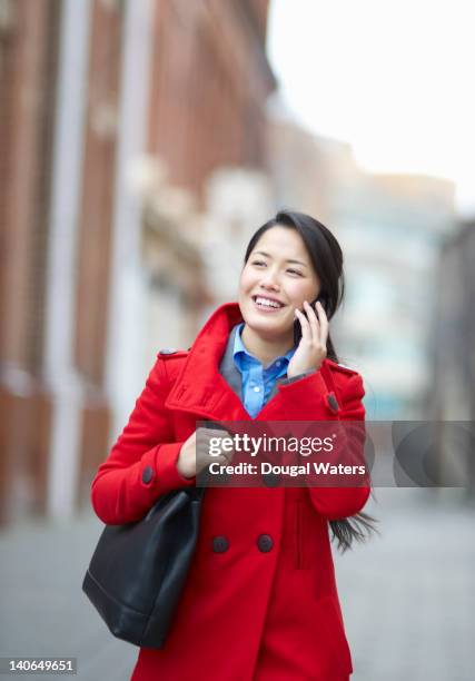 asian woman using mobile phone in street. - nepalese ethnicity - fotografias e filmes do acervo