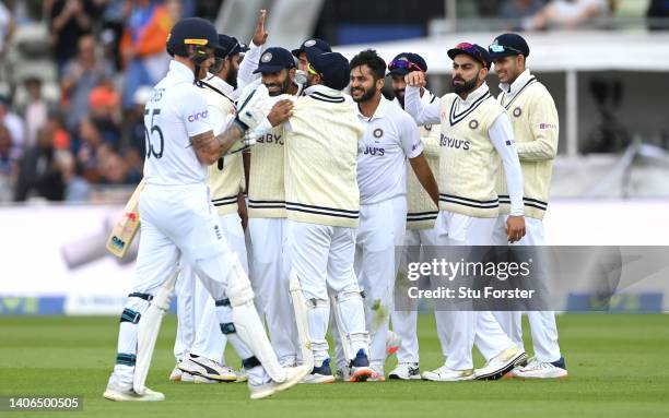 England batsman Ben Stokes reacts after being dismissed, caught by India captain Jasprit Bumrah who is congratulated by team mates during day three...