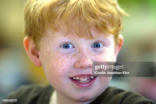freckle-faced boy's face lights up during class. - freckle faced stockfoto's en -beelden