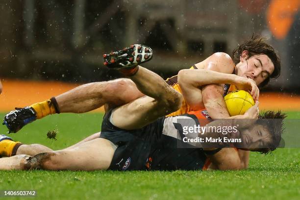 Jai Newcombe of the Hawks contests the ball with Callan Ward of the Giants with during the round 16 AFL match between the Greater Western Sydney...