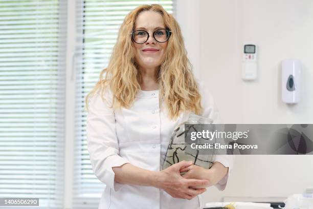 adult confidence doctor holds a jar full of medicinal leeches and looking at camera - leeches stock pictures, royalty-free photos & images