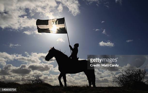 Woman on horseback flies the flag of Cornwall during the annual processional play to celebrate St Piran, patron saint of tinners and regarded by many...