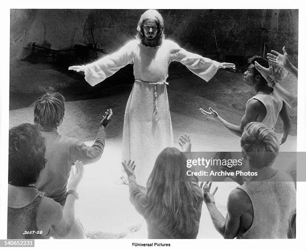 The Apostles raise their arms to Ted Neeley after he has accused them of not caring if he comes or goes in a scene from the film 'Jesus Christ...