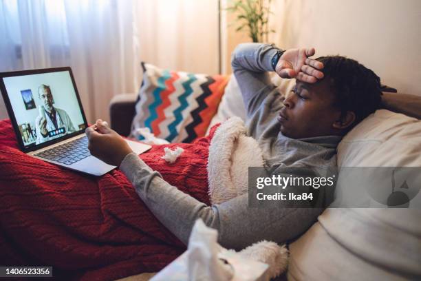 joven afroamericano enfermo que tiene interacción con el médico a través de una computadora portátil - consultation lake fotografías e imágenes de stock