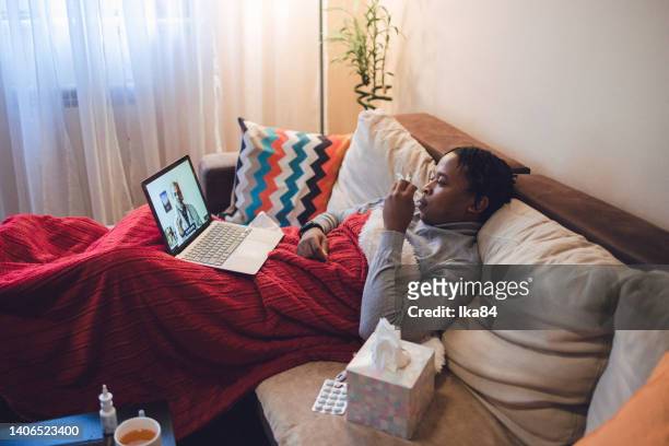 joven afroamericano enfermo que tiene interacción con el médico a través de una computadora portátil - consultation lake fotografías e imágenes de stock