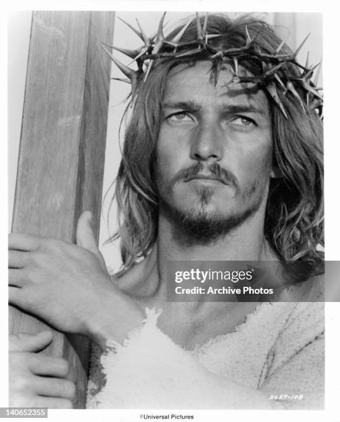 Ted Neeley, with a crown of thorns on his head, carries the cross to which Roman soldiers will crucify him in a scene from the film 'Jesus Christ...