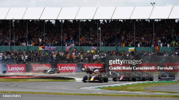 Max Verstappen of the Netherlands driving the Oracle Red Bull Racing RB18 leads Carlos Sainz of Spain driving the Ferrari F1-75 and the rest of the...