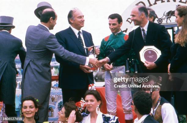 Jean Luis Hermes, Aga Khan, Jockey Gerald Mosse und Baron du Breuil beim Pferderennen in Hamburg Bahrenfeld, Deutschland 1985.
