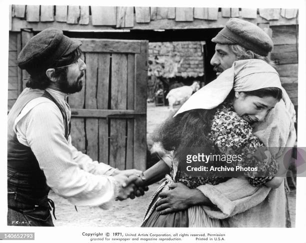 Leonard Frey shaking hand of Topol while Norma Crane hugs him in a scene from the film 'Fiddler On The Roof', 1971.
