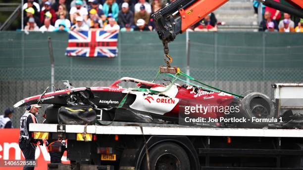 The car of Zhou Guanyu of China and Alfa Romeo F1 is recovered from the track after a crash at the start during the F1 Grand Prix of Great Britain at...