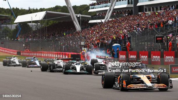 Zhou Guanyu of China driving the Alfa Romeo F1 C42 Ferrari makes contact and crashes with George Russell of Great Britain driving the Mercedes AMG...