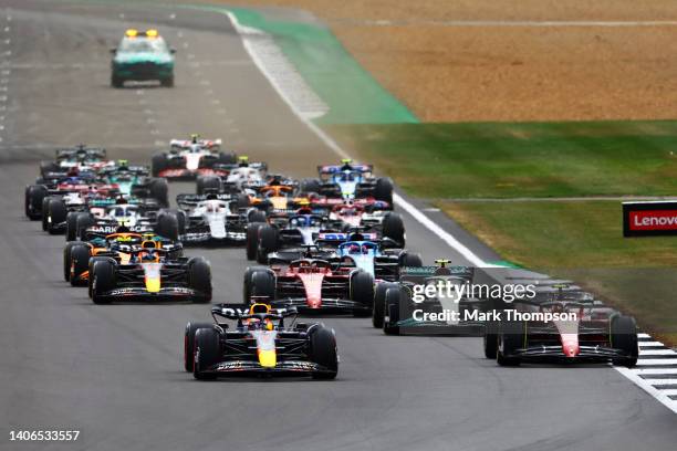 Max Verstappen of the Netherlands driving the Oracle Red Bull Racing RB18 leads Carlos Sainz of Spain driving the Ferrari F1-75 and the rest of the...