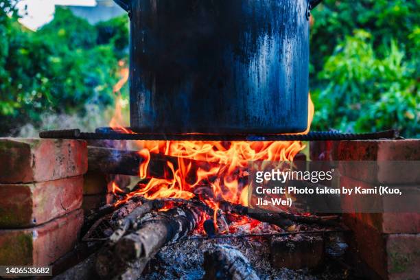 use big pot cooking with burning firewood - fuego al aire libre fotografías e imágenes de stock