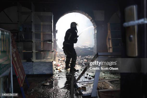 Firefighters work to extinguish a fire at a shopping mall after it was struck by a missile on July 03, 2022 in Sloviansk, Ukraine. The attack was one...