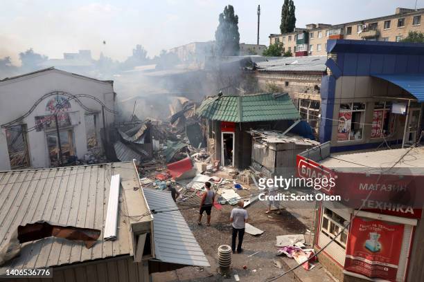 People look over the wreckage after a missile stuck a shopping mall on July 03, 2022 in Sloviansk, Ukraine. The attack was one of many in the city...
