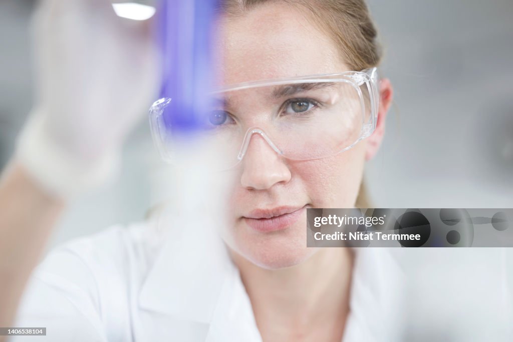 Pharmaceutical, Biotech Research and Development. Female Chemist analyzing on chemical sample through a test tube at laboratory.