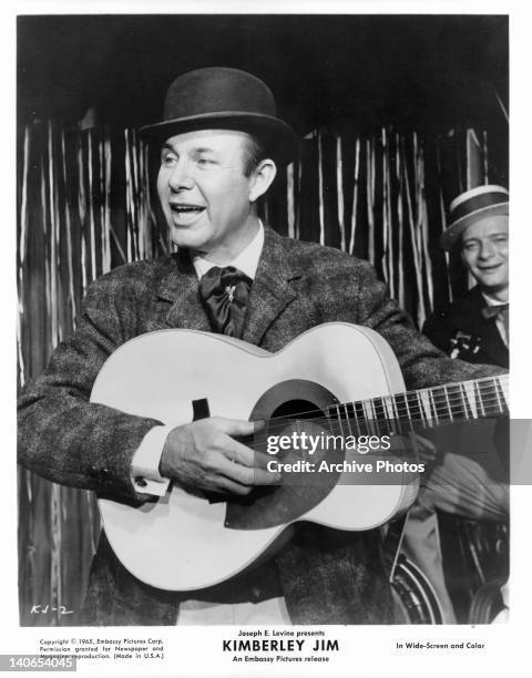 Jim Reeves playing guitar in a scene from the film 'Kimberley Jim', 1965.