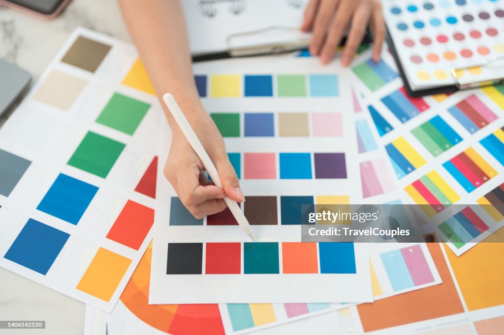 Graphic designer at work. Color swatch samples. Artist drawing something on graphic tablet at the office. Graphic designer creativity editor ideas designer concept