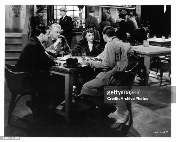Huntley and Nigel Bruce watch Laraine Day preparing to leave Robert Young wearing a pith helmet in a scene from the film 'Journey For Margaret', 1942.