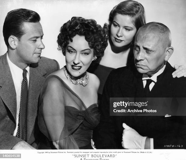 William Holden and Gloria Swanson pose with others in a scene from the film 'Sunset Boulevard', 1950.