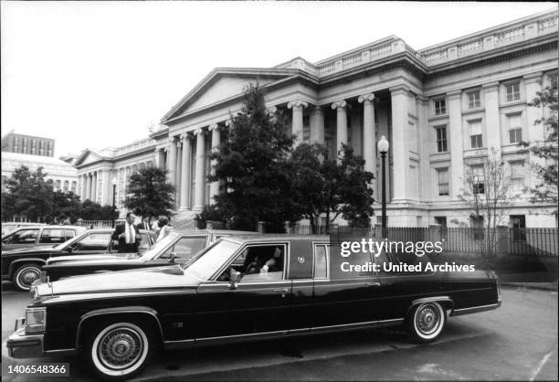 Die Abbildung zeigt ein Gebäude der US-Regierung mit ein paar Limousinen auf dem Parkplatz.