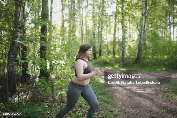 a teenage kid girl on run in woods forest - fat girls stock-fotos und bilder