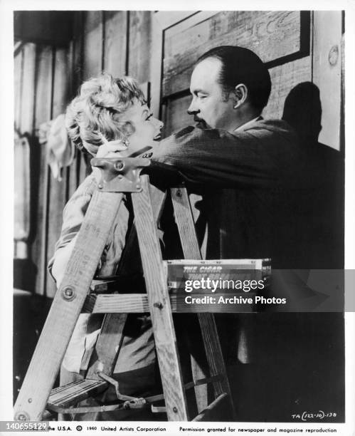 Lucille Ball and Bob Hope up close next to ladder in a scene from the film 'The Facts Of Life', 1960.