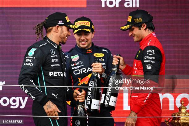 Race winner Carlos Sainz of Spain and Ferrari, Second placed Sergio Perez of Mexico and Oracle Red Bull Racing and Third placed Lewis Hamilton of...