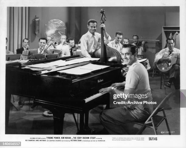 Tyrone Power plays piano along with band members in a scene from the film 'The Eddy Duchin Story', 1956.