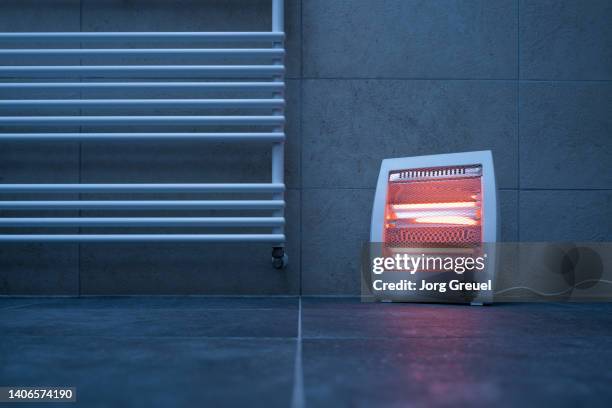 electric infrared heater (quartz heater) next to radiator - naast stockfoto's en -beelden