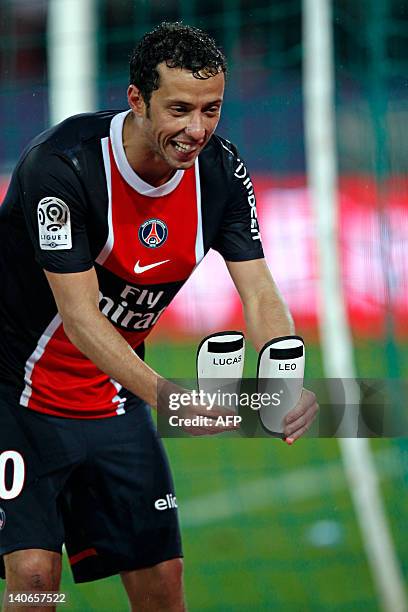 Paris Saint-Germain's Brazilian midfielder Nene shows his two shin guards, with his two sons' names Lucas and Leo written on them, after scoring a...