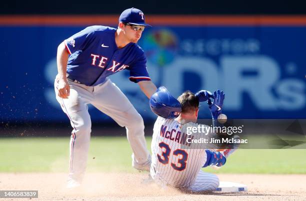 James McCann of the New York Mets slides safely into second base for a seventh inning double as he is hit by the throw to Corey Seager of the Texas...