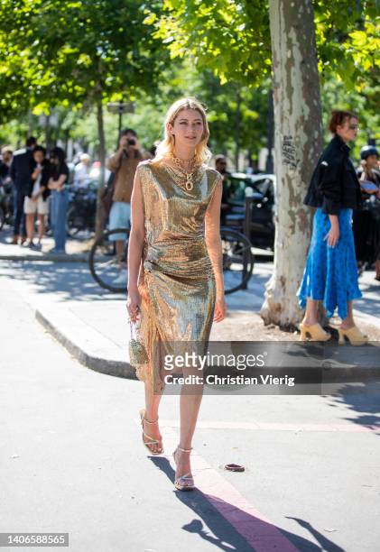 Vanille Verloes seen wearing golden dress, heels, bag outside Paco Rabanne during Paris Fashion Week on July 03, 2022 in Paris, France.