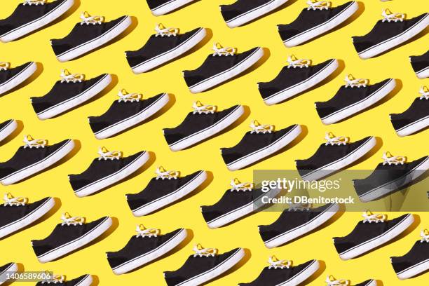 pattern of black and white canvas and rubber surfer and skater sneakers with white laces, on a yellow background. concept of skateboarding, surfing, fashion, sneakers, modern and retro. - sneaker shoe print stock pictures, royalty-free photos & images